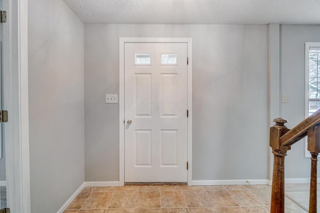 foyer entrance featuring a textured ceiling