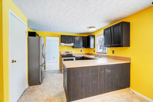 kitchen with a textured ceiling, appliances with stainless steel finishes, sink, kitchen peninsula, and light tile patterned floors