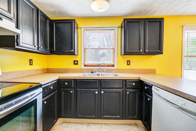 kitchen featuring stainless steel electric range oven, dishwasher, sink, and a textured ceiling