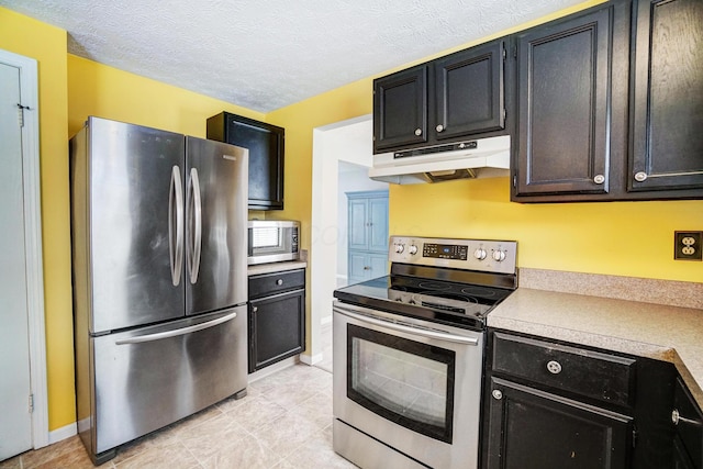 kitchen with light tile patterned floors, appliances with stainless steel finishes, and a textured ceiling