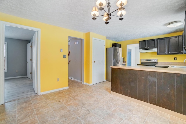 kitchen with sink, hanging light fixtures, appliances with stainless steel finishes, a textured ceiling, and a chandelier