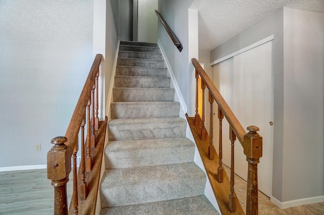 stairway featuring hardwood / wood-style floors and a textured ceiling