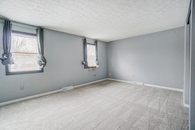 empty room featuring carpet and a textured ceiling