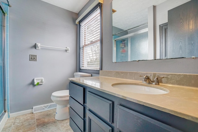 bathroom featuring an enclosed shower, vanity, and toilet