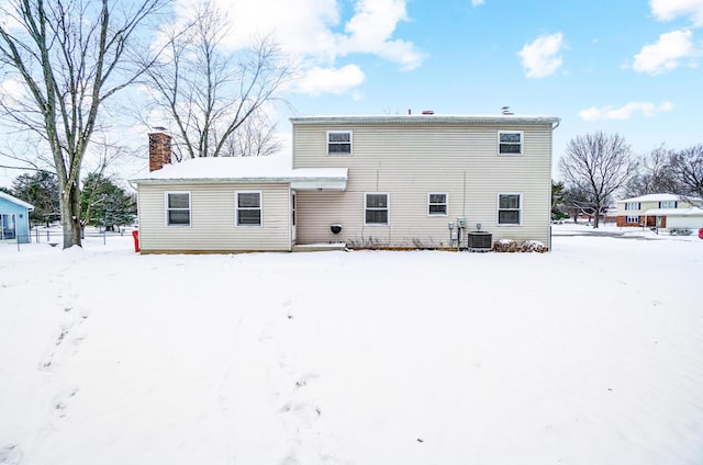 snow covered property with central air condition unit