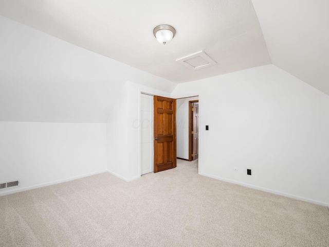 bonus room with vaulted ceiling and light colored carpet