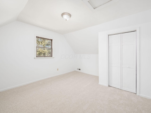 bonus room featuring vaulted ceiling and light carpet