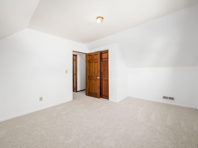 additional living space with light colored carpet and lofted ceiling