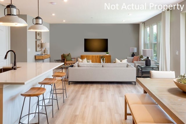 living room with light wood-type flooring and recessed lighting