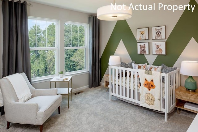 carpeted bedroom with a nursery area, multiple windows, visible vents, and baseboards