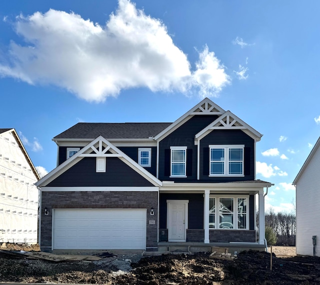 craftsman inspired home featuring a garage and covered porch