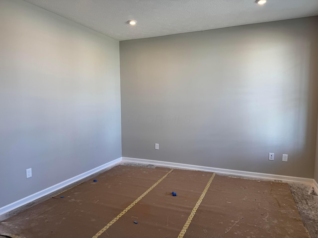 unfurnished room with baseboards, a textured ceiling, and recessed lighting