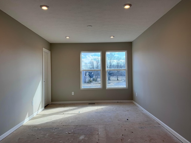 unfurnished room featuring recessed lighting and baseboards