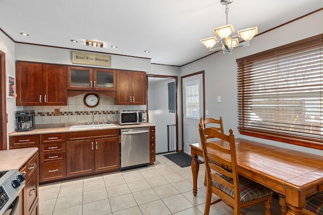 kitchen with backsplash, sink, pendant lighting, dishwasher, and range