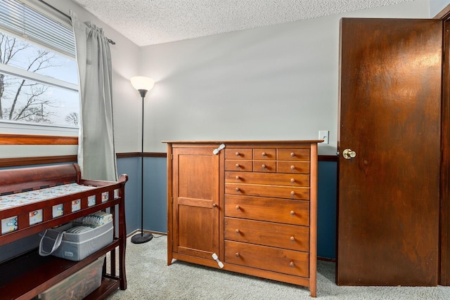 bedroom featuring light carpet and a textured ceiling