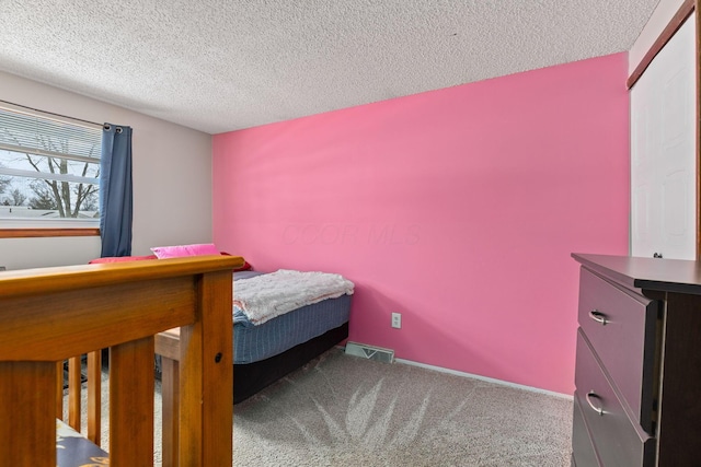 carpeted bedroom featuring a textured ceiling