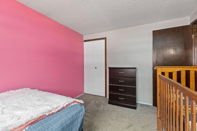 bedroom with a textured ceiling, carpet floors, and a closet