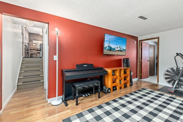 misc room featuring a textured ceiling and light wood-type flooring