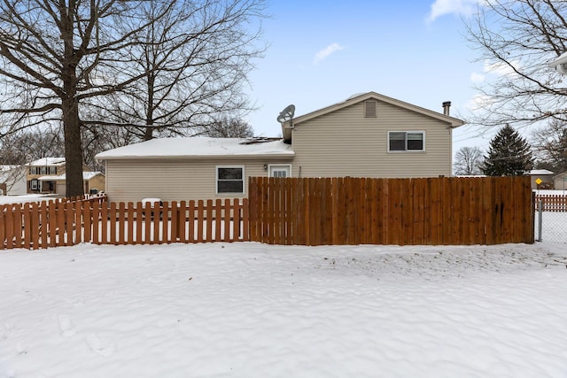 view of snow covered rear of property