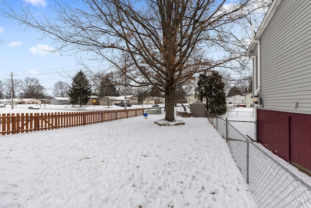 snowy yard with a storage shed