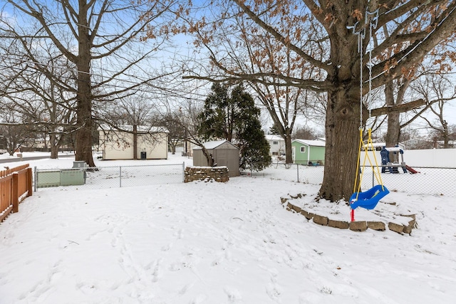 yard layered in snow with a storage unit