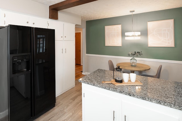 kitchen with light wood-type flooring, black refrigerator with ice dispenser, decorative light fixtures, dark stone countertops, and white cabinetry