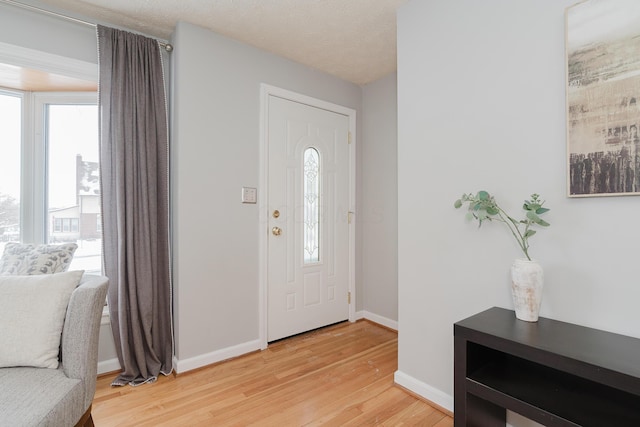 foyer entrance with wood-type flooring and a textured ceiling