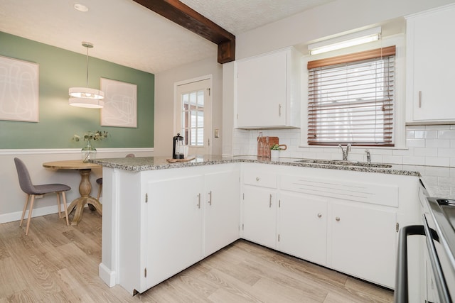 kitchen with sink, hanging light fixtures, tasteful backsplash, kitchen peninsula, and white cabinets