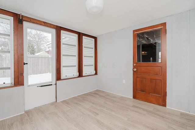 foyer featuring wooden walls and light hardwood / wood-style flooring