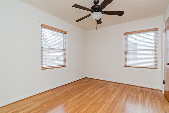 empty room with ceiling fan, light hardwood / wood-style flooring, and plenty of natural light