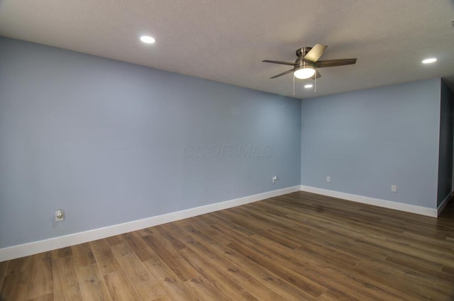 unfurnished room with ceiling fan and dark hardwood / wood-style flooring