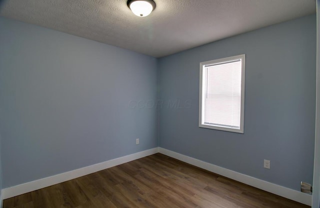 spare room with hardwood / wood-style flooring and a textured ceiling