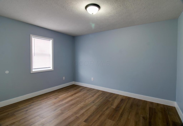 unfurnished room featuring hardwood / wood-style floors and a textured ceiling