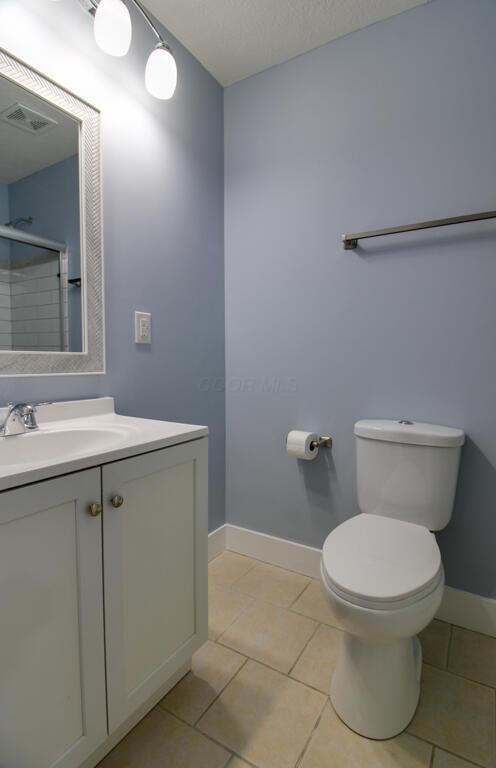 bathroom featuring tile patterned flooring, vanity, and toilet