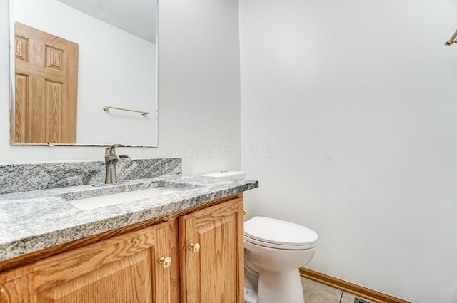 bathroom with tile patterned floors, vanity, and toilet