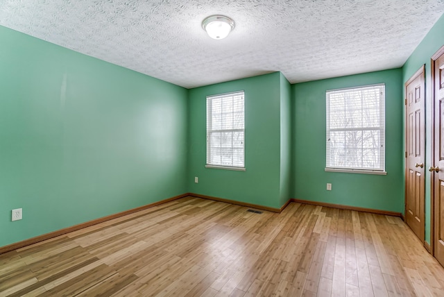 empty room featuring light hardwood / wood-style floors and a textured ceiling