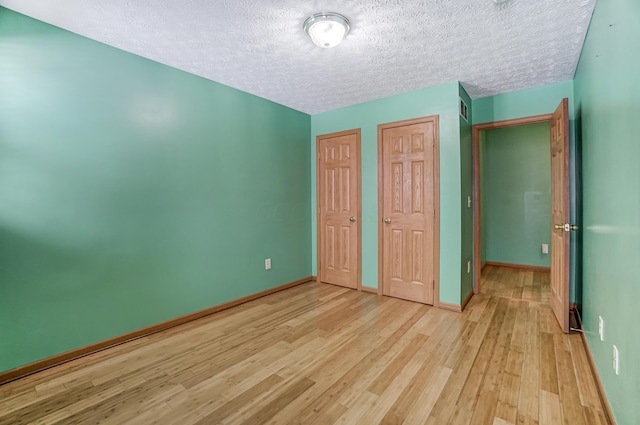 unfurnished bedroom featuring a textured ceiling and light wood-type flooring