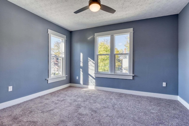 unfurnished room featuring carpet flooring, a textured ceiling, ceiling fan, and plenty of natural light