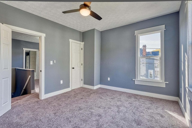 unfurnished bedroom featuring a textured ceiling, carpet floors, and ceiling fan