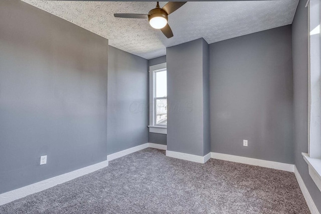 empty room featuring a textured ceiling, ceiling fan, and carpet