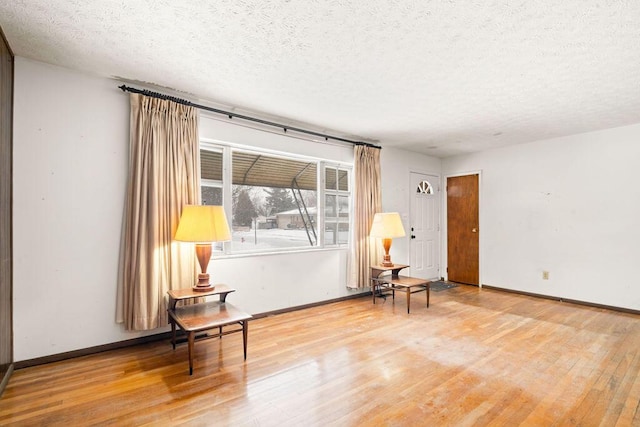 living area featuring a textured ceiling and wood-type flooring