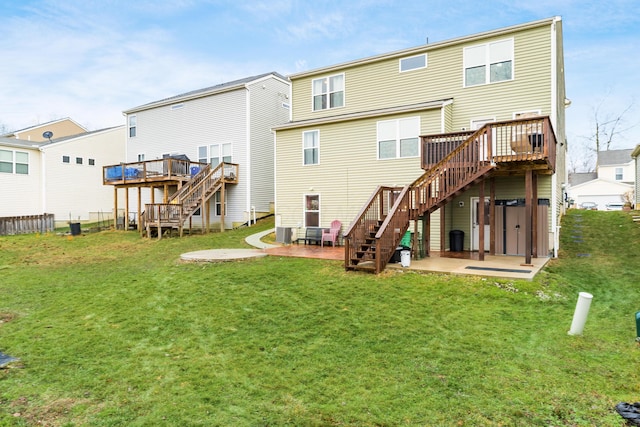 rear view of house featuring a lawn, a patio, and a deck