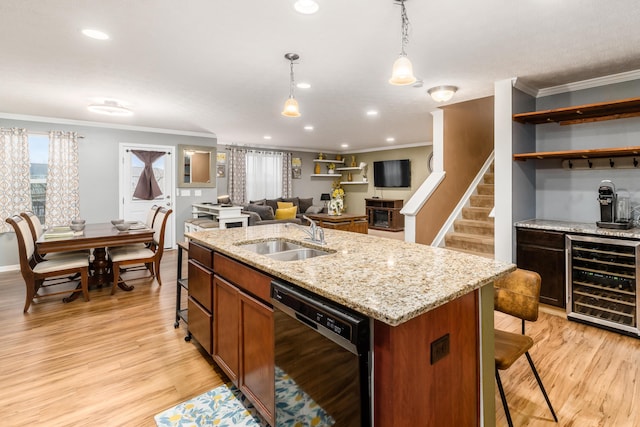 kitchen featuring pendant lighting, sink, a kitchen island with sink, black dishwasher, and beverage cooler