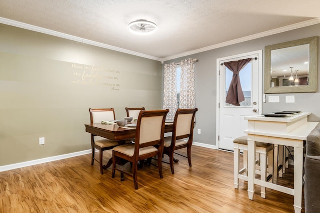 dining room featuring hardwood / wood-style flooring, ornamental molding, and a textured ceiling