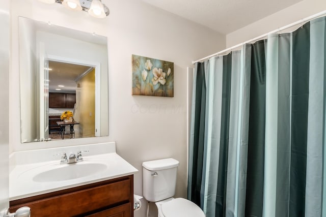 bathroom with vanity, curtained shower, and toilet