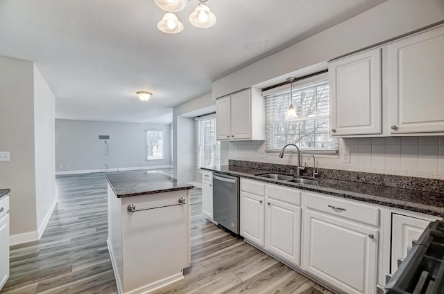 kitchen featuring dishwasher, white cabinetry, hanging light fixtures, and sink