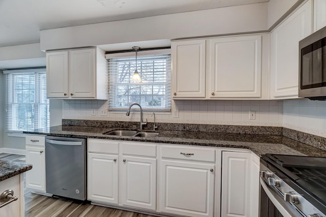 kitchen with pendant lighting, sink, white cabinetry, and stainless steel appliances