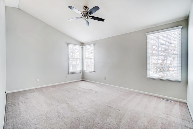 carpeted empty room featuring plenty of natural light, lofted ceiling, and ceiling fan