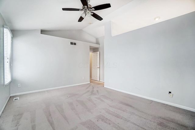 spare room featuring ceiling fan, light colored carpet, and lofted ceiling