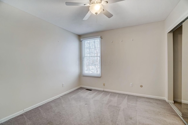 unfurnished bedroom with ceiling fan, a closet, and light carpet